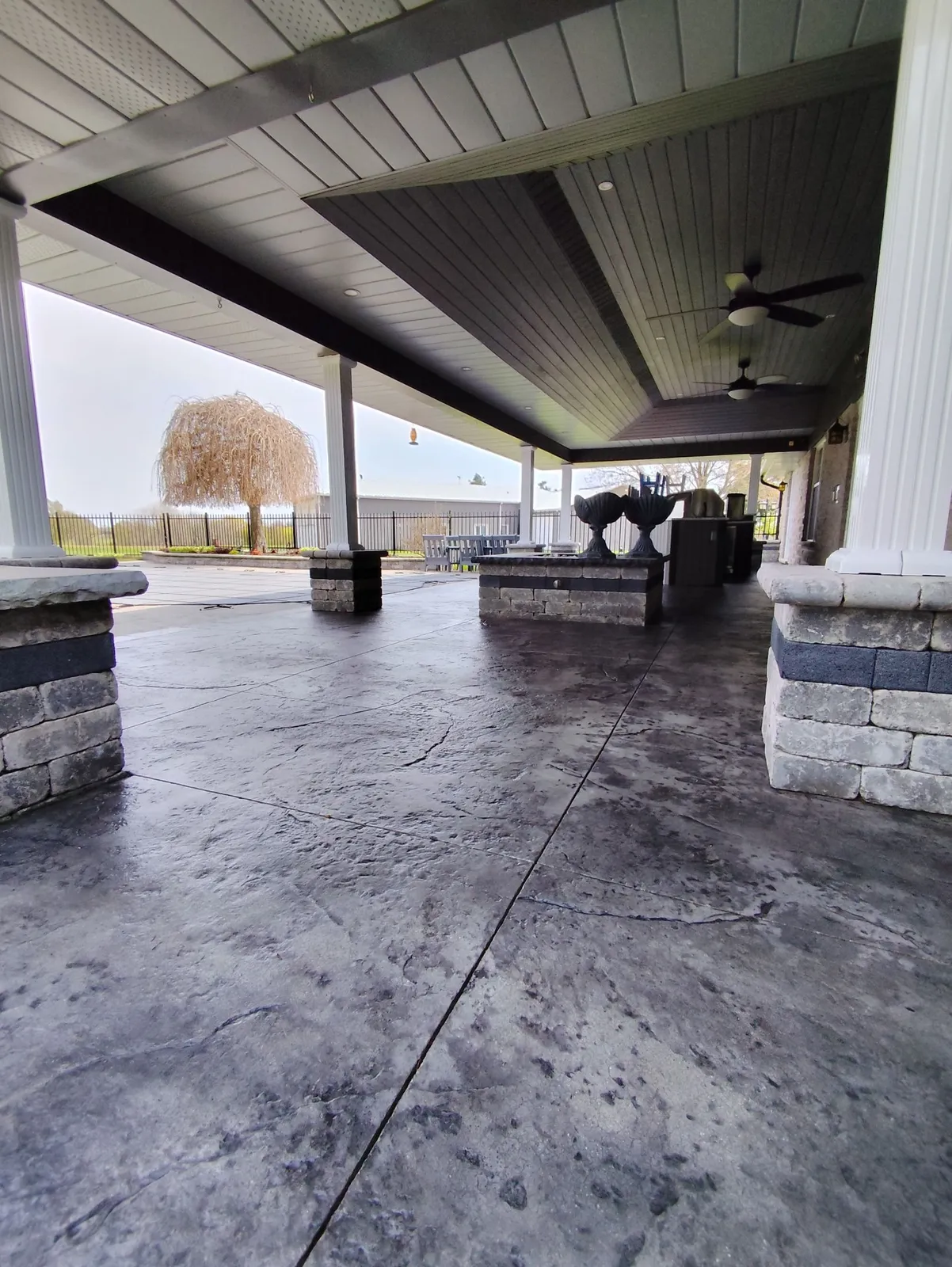 Covered stamped concrete patio with stone columns